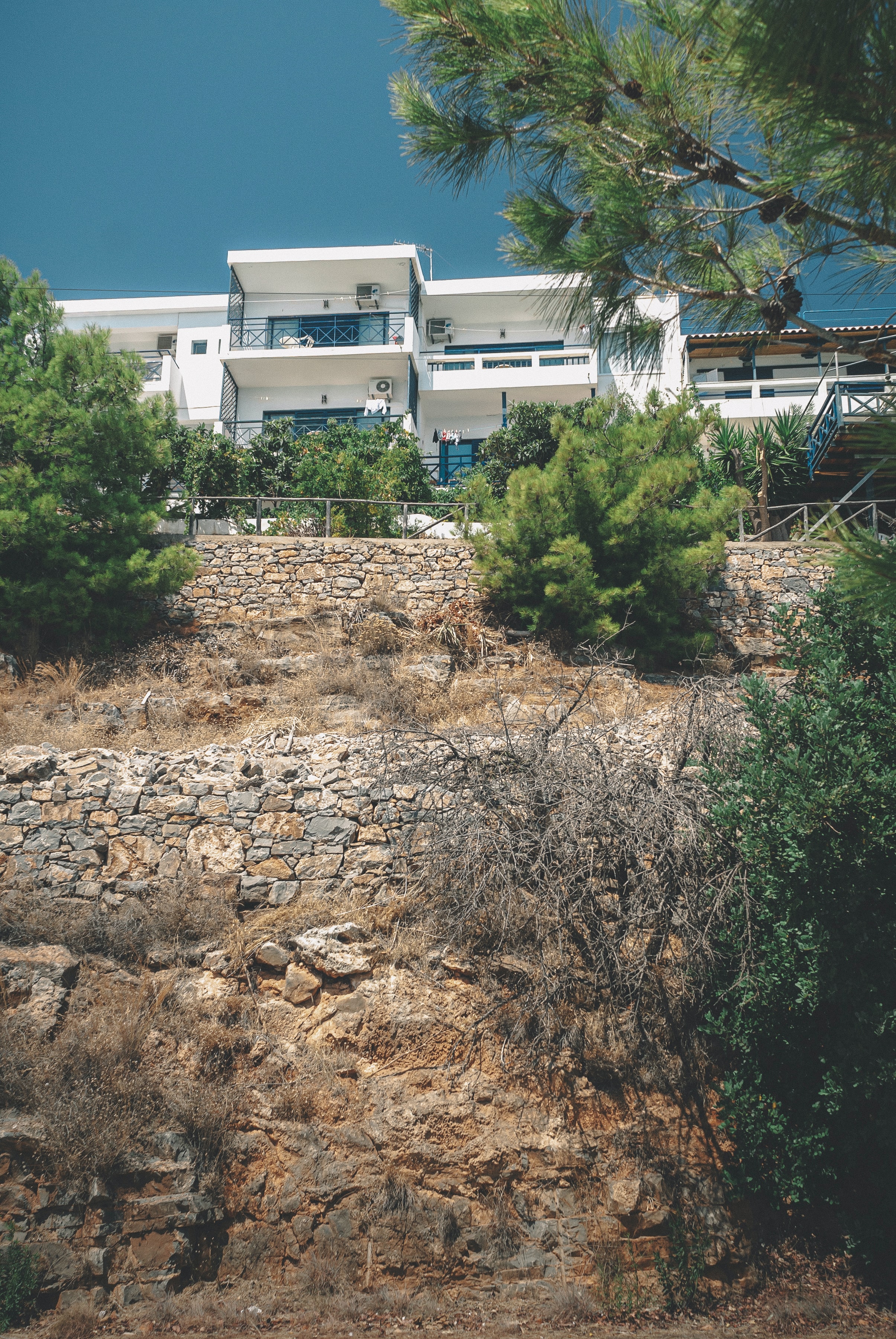lower view of white house over two retaining walls